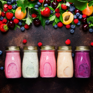 Berry colored smoothies in milk jars.