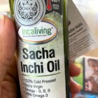 A bottle of Incaliving cold pressed sacha inchi oil held in a hand