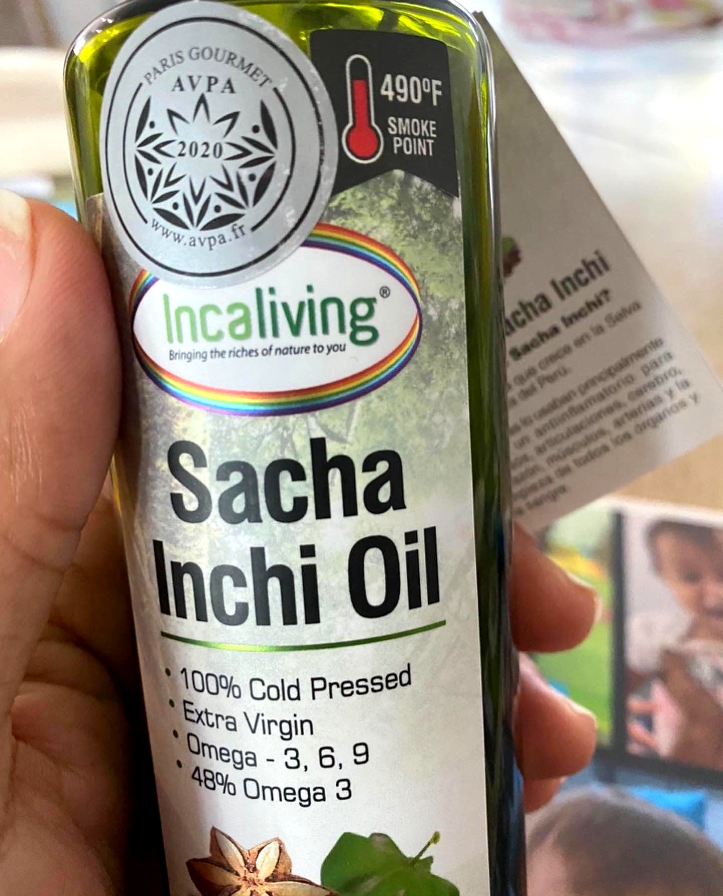 A bottle of Incaliving cold pressed sacha inchi oil held in a hand